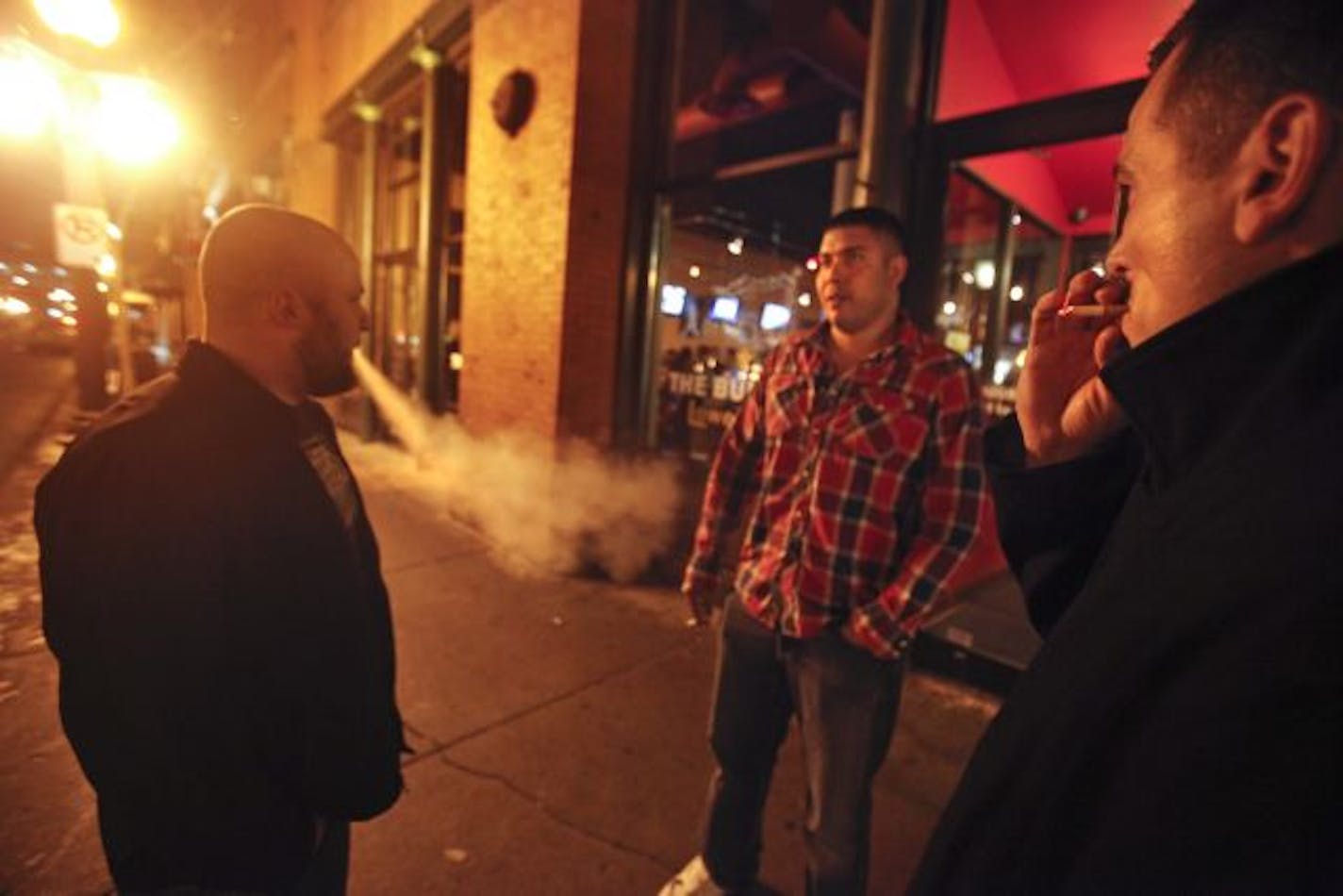 Justin Scearcy, Armando Gutierrez and Nick Kaufenberg grabbed a smoke Friday outside the Bulldog Lowertown in St. Paul.