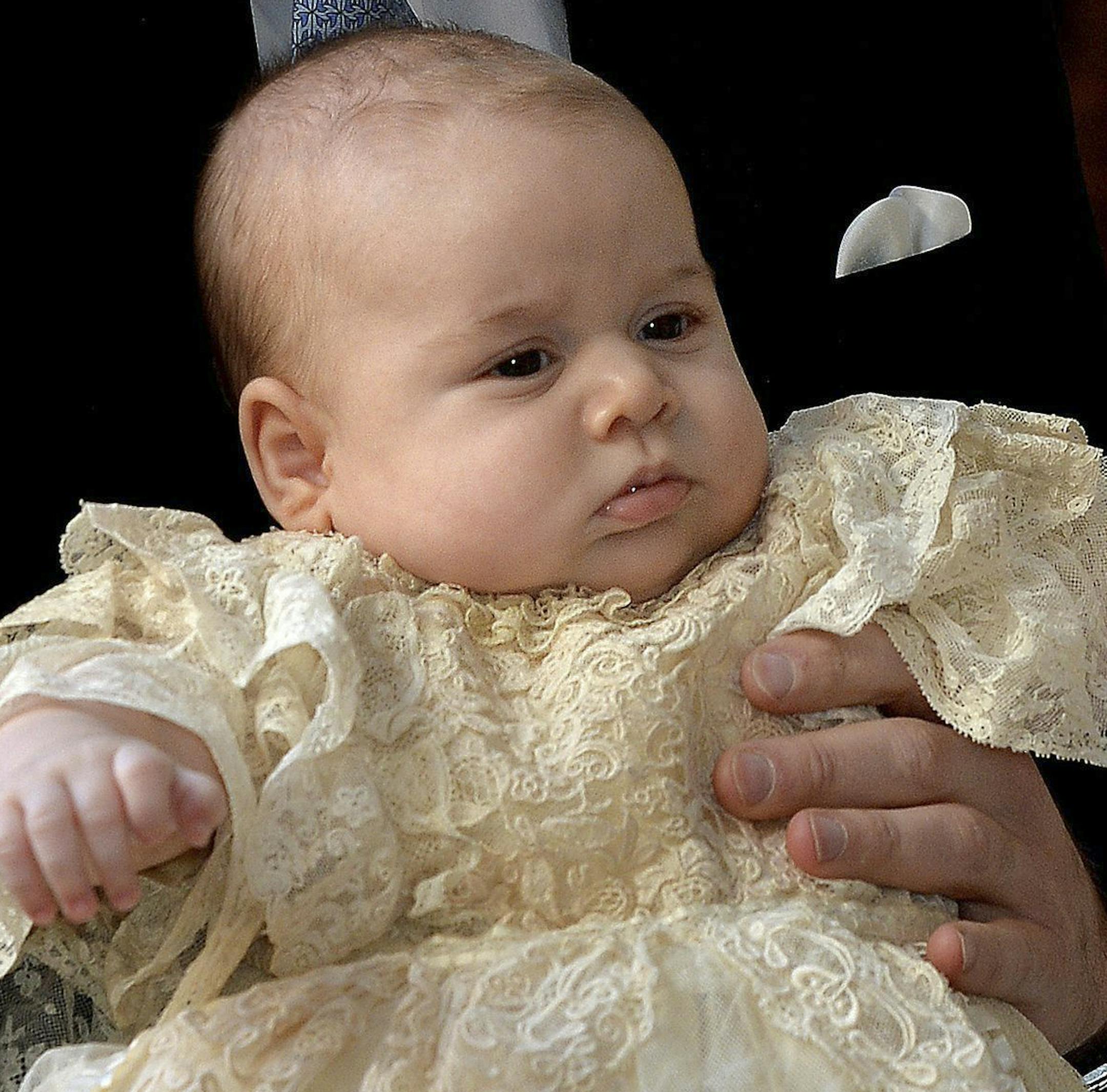 Britain's Prince George is held by his father Prince William as they arrive at Chapel Royal in St James's Palace in London, for the christening of the three month-old Prince Wednesday Oct. 23, 2013. (AP Photo/John Stillwell/Pool)