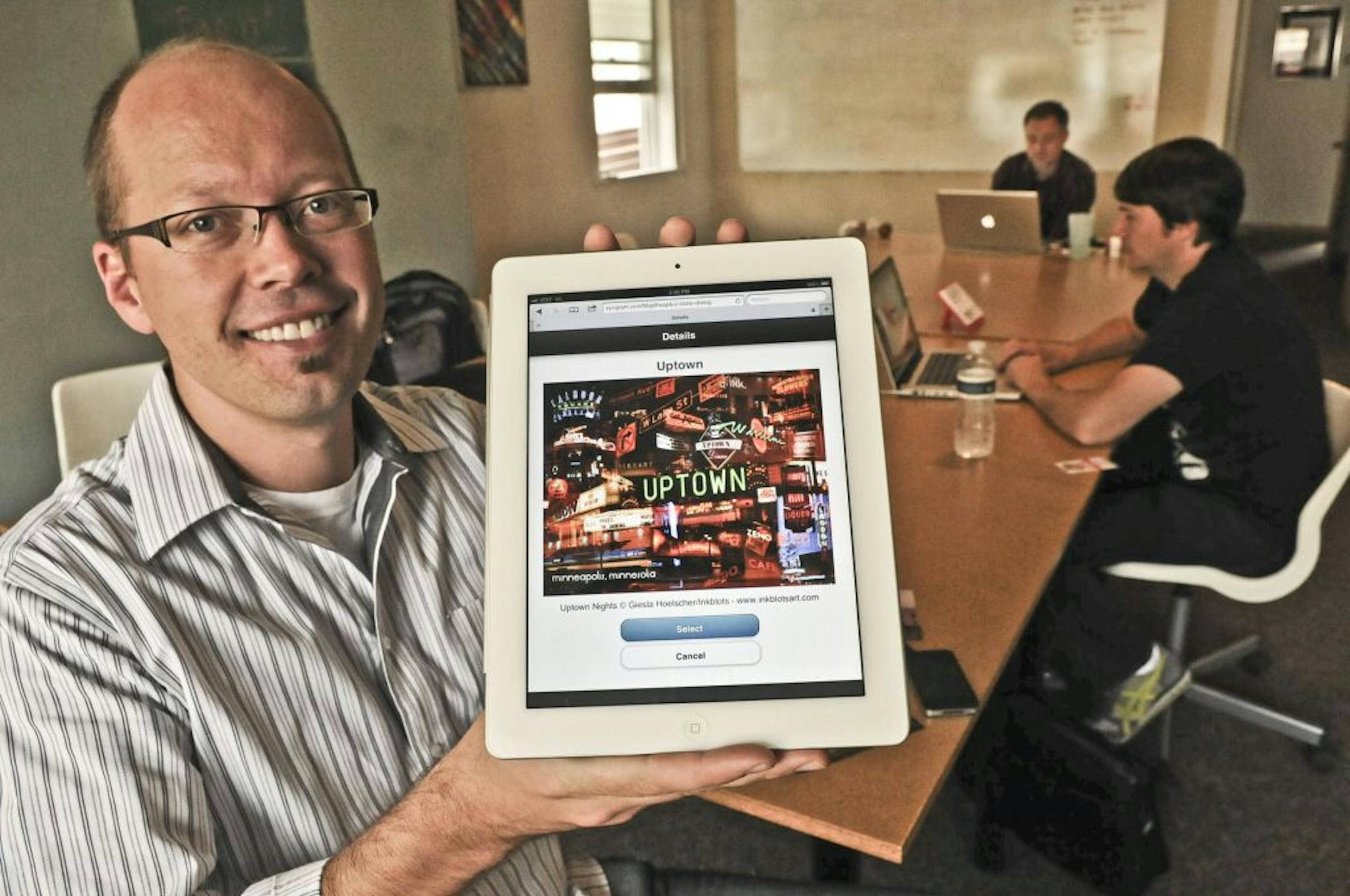 Co-Founder of Zyngram, Zack Steven held an ipad on Friday September 7,2011 in St Paul, Minn., with a postcard of Uptown which is one of dozens of postcards that are mail ready. The St. Paul-based Zyngram mails postcards for you for 99 cents. Consumers type online the message they want to send in the postcard and Zyngram prints it on a postcard and mails it out.