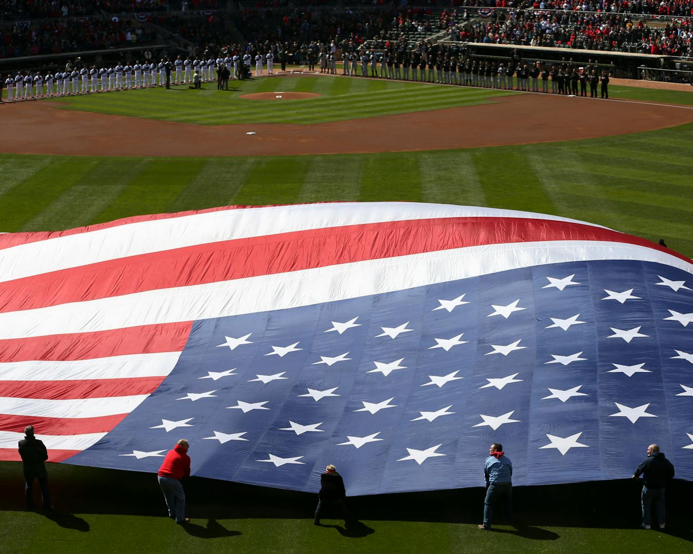 Volunteers unfurled a giant American flag in center field for the National Anthem at the Twins Home opener.