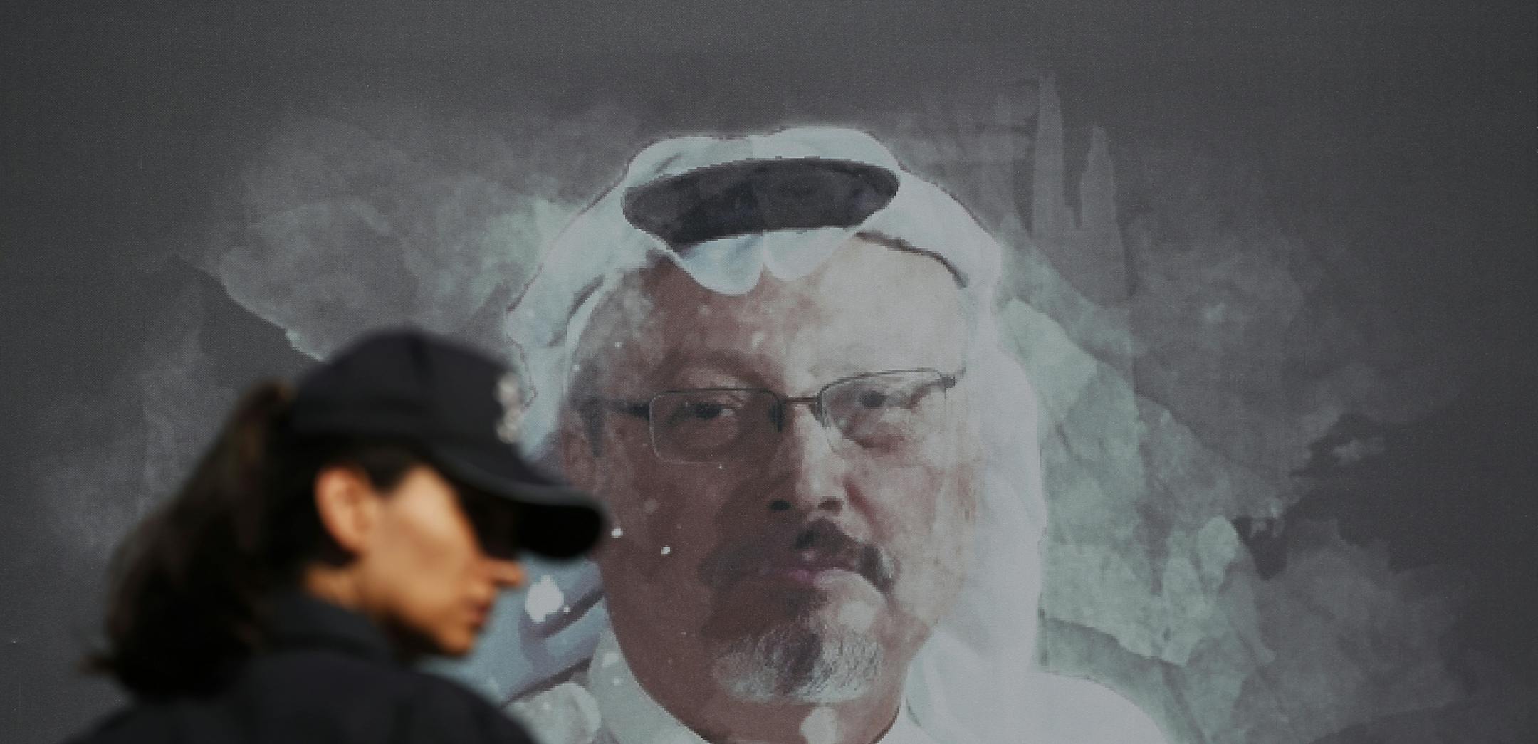 FILE - In this Oct. 2, 2019 file photo, a Turkish police officer walks past a picture of slain Saudi journalist Jamal Khashoggi prior to a ceremony, near the Saudi Arabia consulate in Istanbul, marking the one-year anniversary of his death. A court in Saudi Arabia has sentenced five people to death for the killing of Washington Post columnist Jamal Khashoggi, who was murdered in the Saudi Consulate in Istanbul in October 2018 by a team of Saudi agents. Saudi Arabia's state TV reported Monday, De