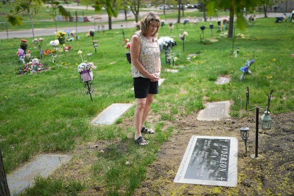 Sandy Cikotte Anderson cleaned off her son Robert’s grave marker at Forest Hill Cemetery in Anoka on Thursday. A second autopsy says that the Maple 