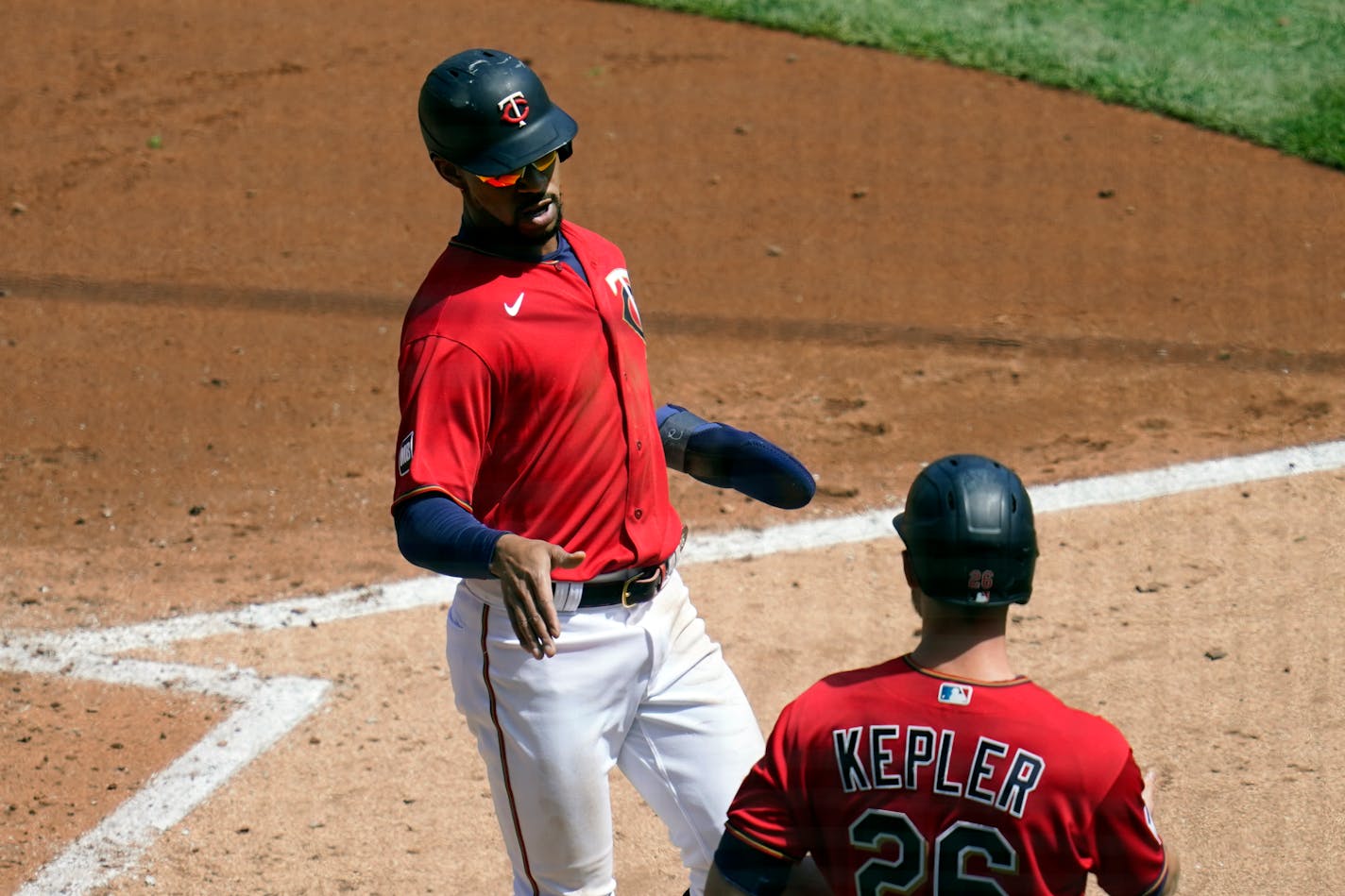 Minnesota Twins' Byron Buxton, left, scores on a two-run single by Minnesota Twins' Willians Astudillo in the third inning of a baseball game, Thursday, May 6, 2021, in Minneapolis. At right is Twins' Max Kepler. (AP Photo/Jim Mone)