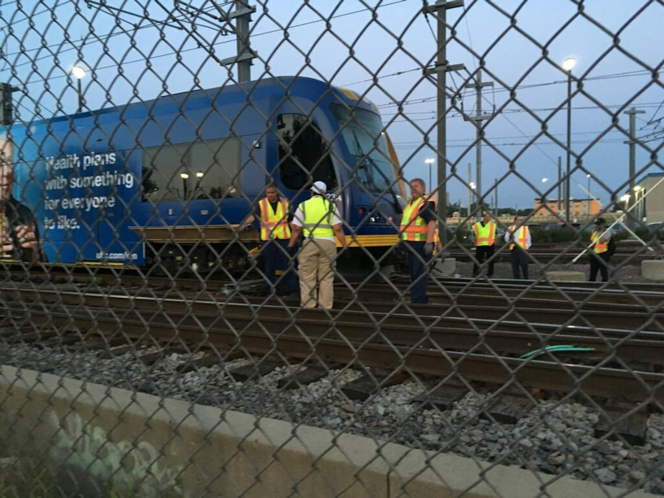 Workers inspect the site near Franklin Avenue where a Blue Line train derailed around 5 a.m.