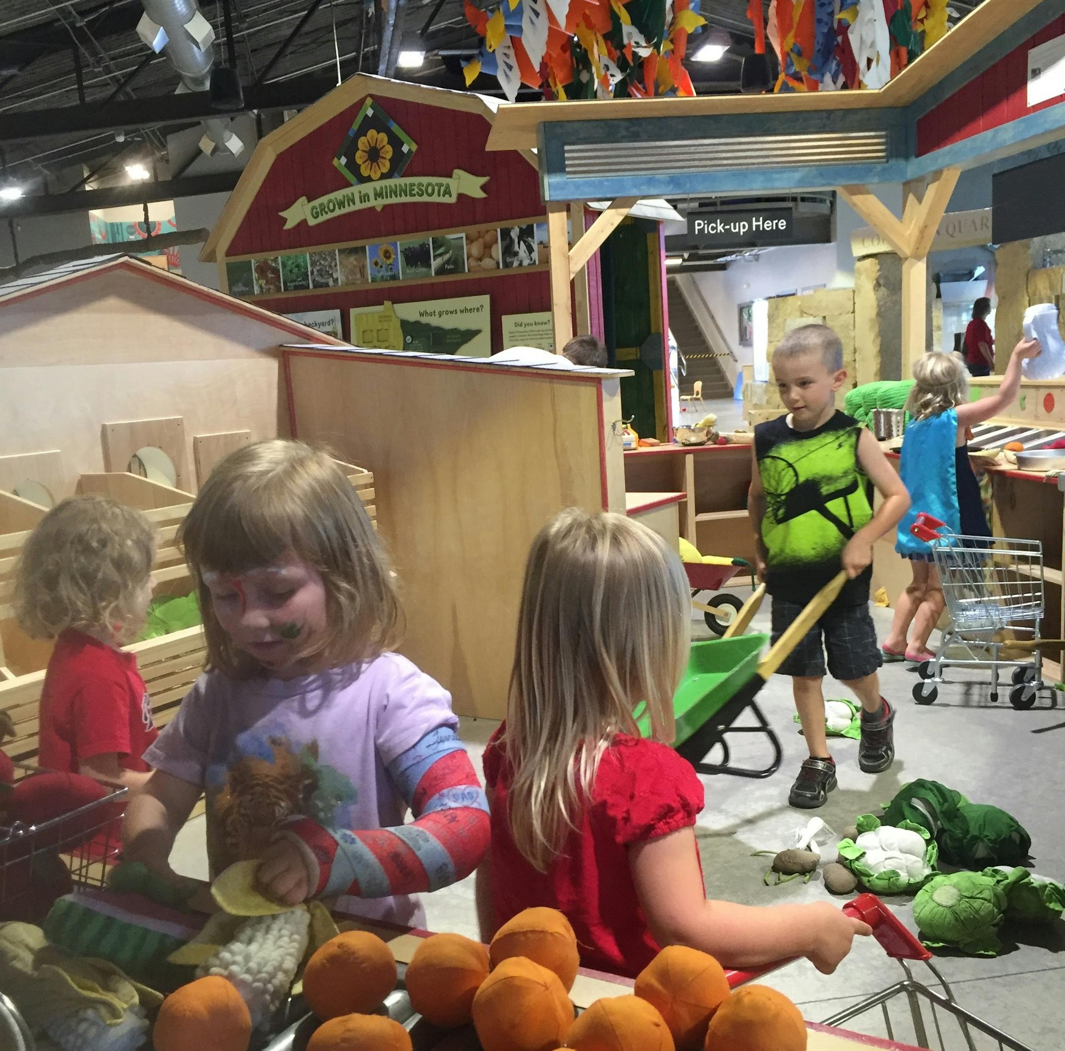 The author’s daughter (foreground) works with stuffed produce in the Children’s Museum’s Grow It Gallery.