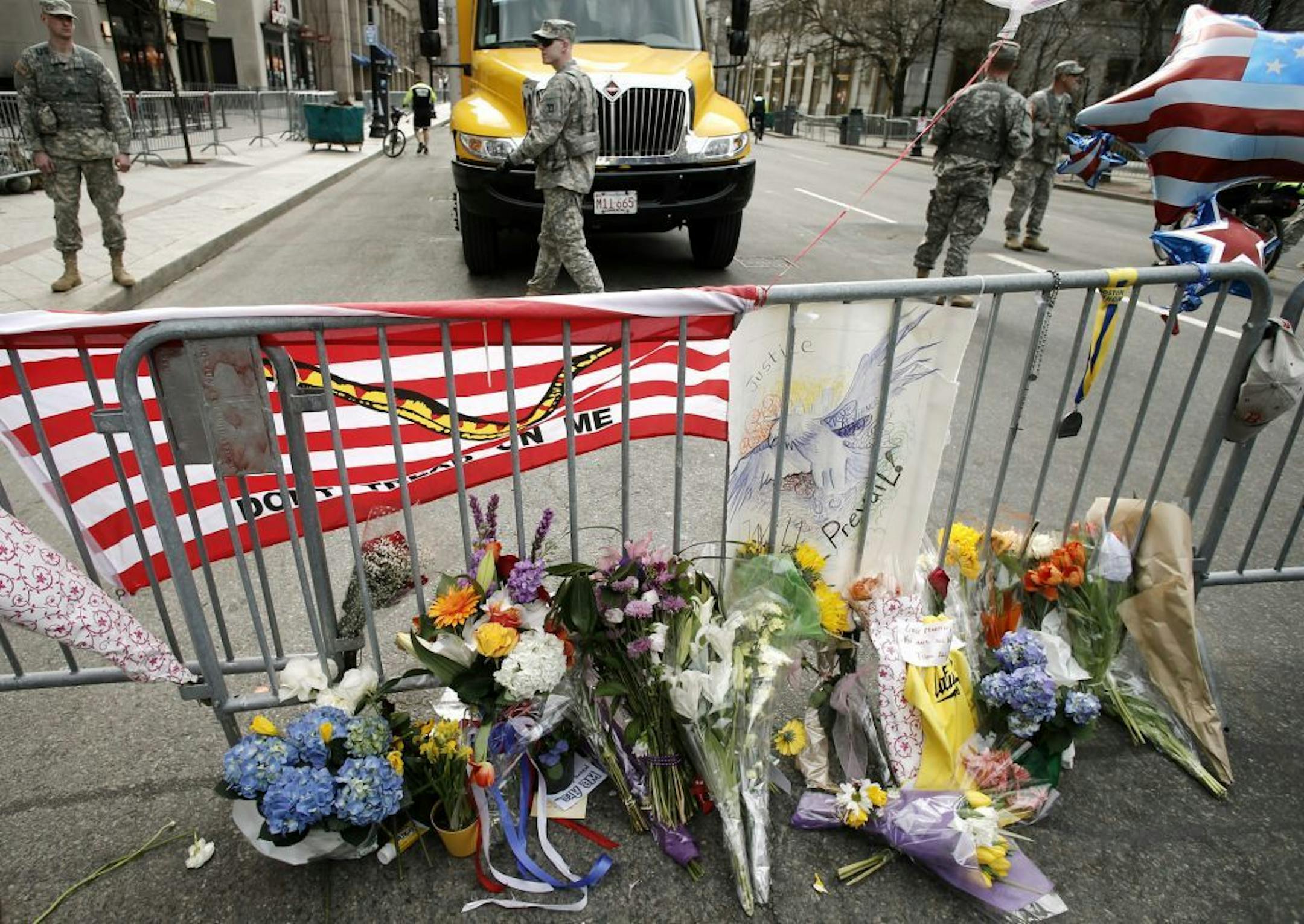 Flowers are placed by a Boston police barricade near the finish line of the Boston Marathon