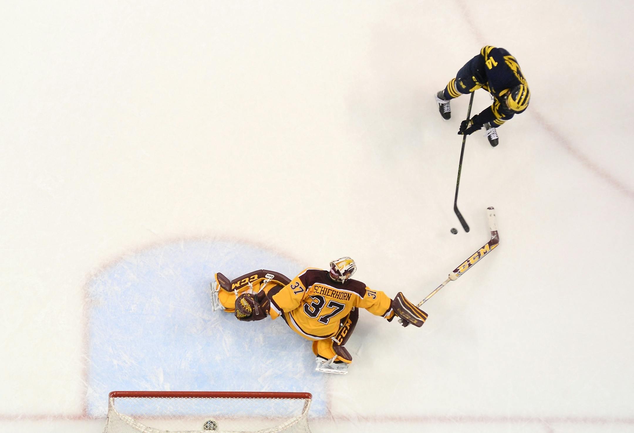 Michigan Wolverines forward Tyler Motte (14) scored on Minnesota Golden Gophers goalie Eric Schierhorn (37) during Saturday night's Big 10 championship game.
