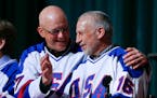 FILE - In this Feb. 21, 2015, file photo, Jack O'Callahan, left, and Mark Pavelich of the 1980 U.S. ice hockey team talk during a "Relive the Miracle"