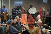 Activists held signs outside the Hennepin County Board meeting on Tuesday, Oct. 10, encouraging fast action on closing the Hennepin Energy Recovery Ce