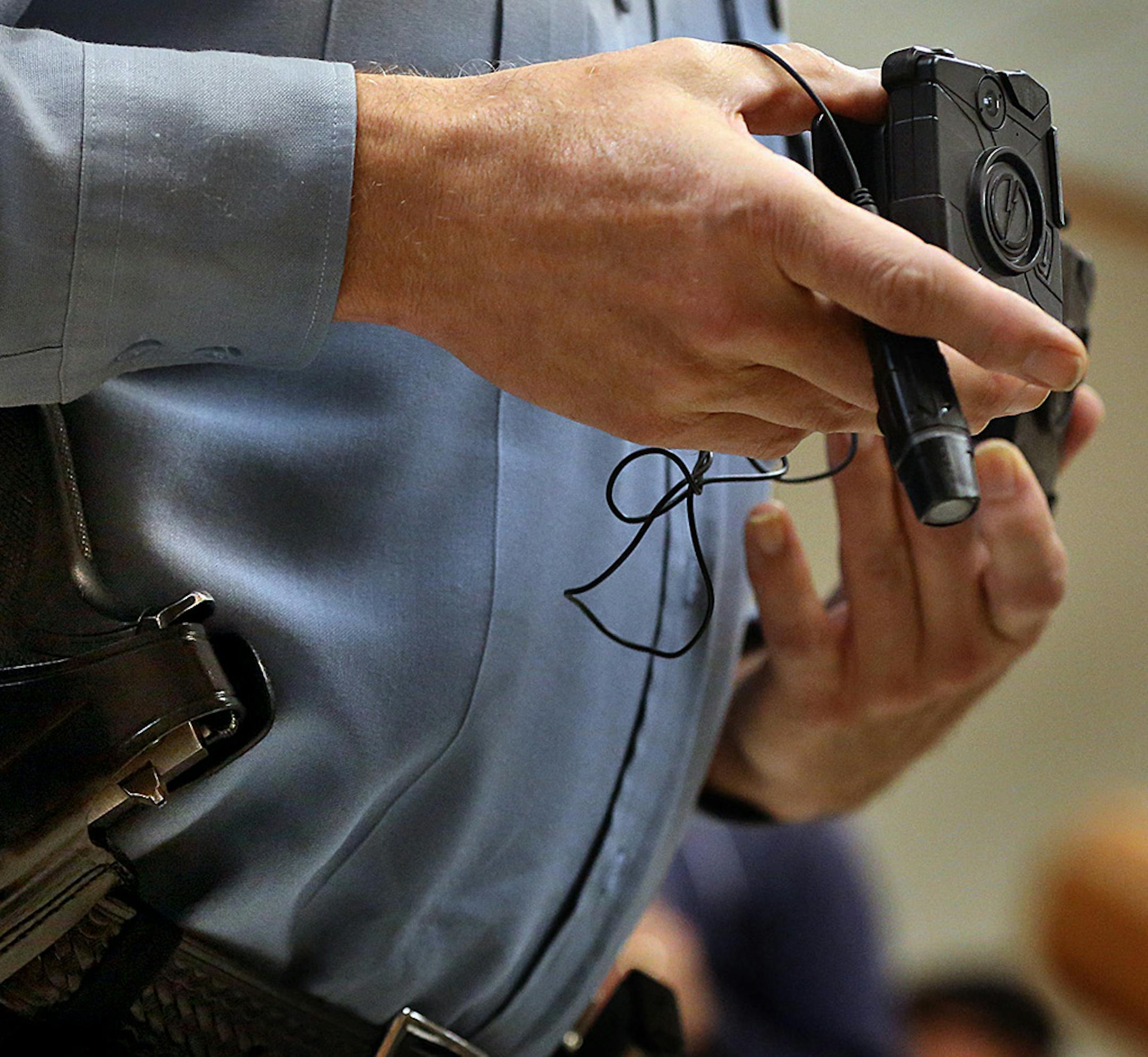 Minneapolis Police Lt. Greg Reinhardt displayed two of the body cameras that will be tested by the department. Both cameras will record 9.5 hours of video (non HD) and are mad by Taser. One camera attaches to an officer&#xed;s body and is completely self-contained, while the other offers a more flexible option, with a thinner camera attached to a battery. ] JIM GEHRZ &#xef; jgehrz@startribune.com / Minneapolis, MN / November 7, 2014 / 1:00 PM / BACKGROUND INFORMATION: Minneapolis police official