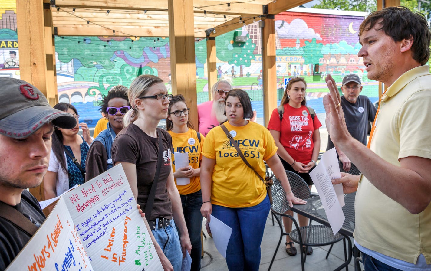 A group of Seward Co-op workers and members of organizations promoting their efforts to unionize presented their issues to Nick Seeberger, right, Seward Co-op operations manager.