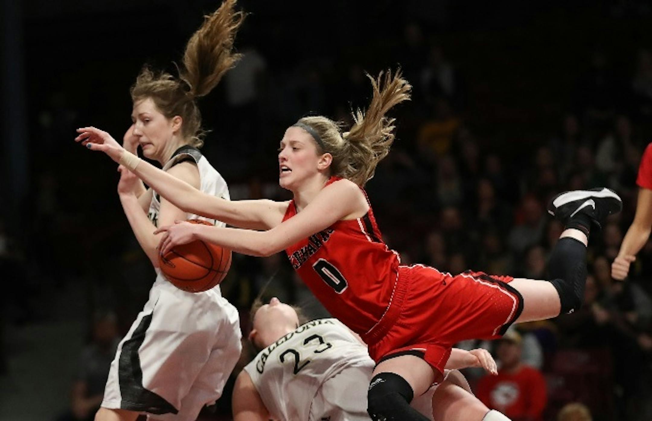 As Minnehaha Academy guard Taytum Rhoades (0) drove to the basket, she ran into Caledonia guards Katie Tornstrom (23) and Kaitlin Conniff (12) in the Class 2A girls' basketball title game Saturday.