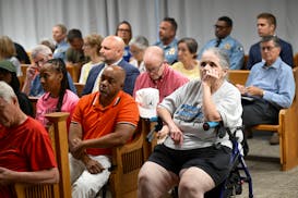 Community members and law enforcement listen to public comment on the proposed police contract Monday during a Minneapolis City Council meeting at the