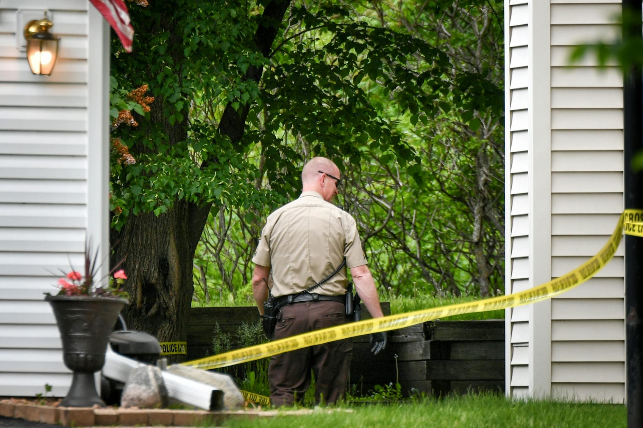 A Hennepin County Sheriff's investigator looked behind the home in which two bodies were found Thursday morning.
