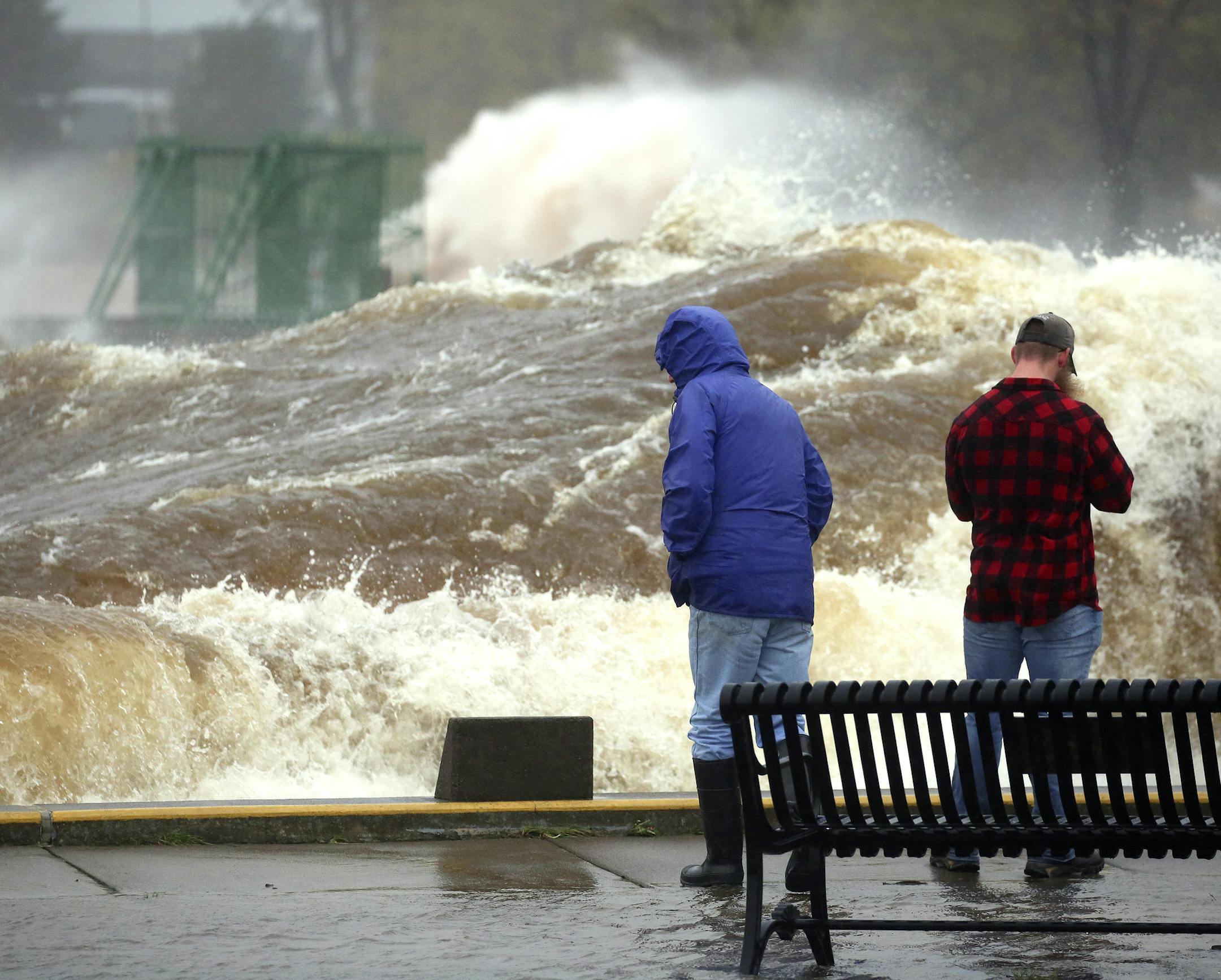T10.10.2018 -- Steve Kuchera -- 101118.N.DNT.WavesC2 -- A large wave rolls past two spectators and down the length of the Duluth Ship Canal on Wednesday morning. Steve Kuchera / skuchera@duluthnews.com