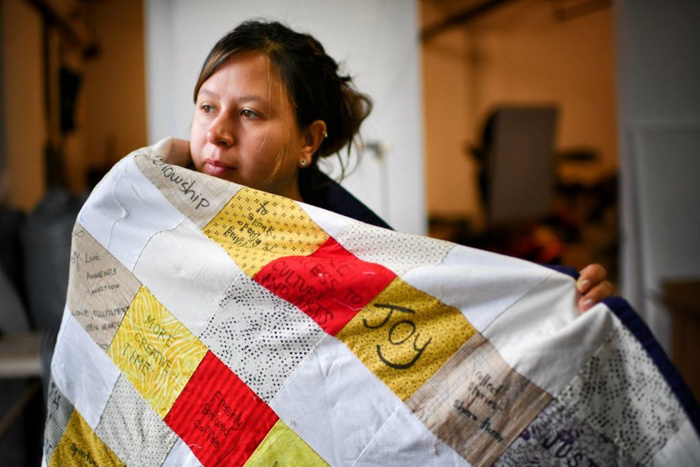 Maggie Thompson, artist, with some of the quilt pieces she is putting together with written submissions from around the world.