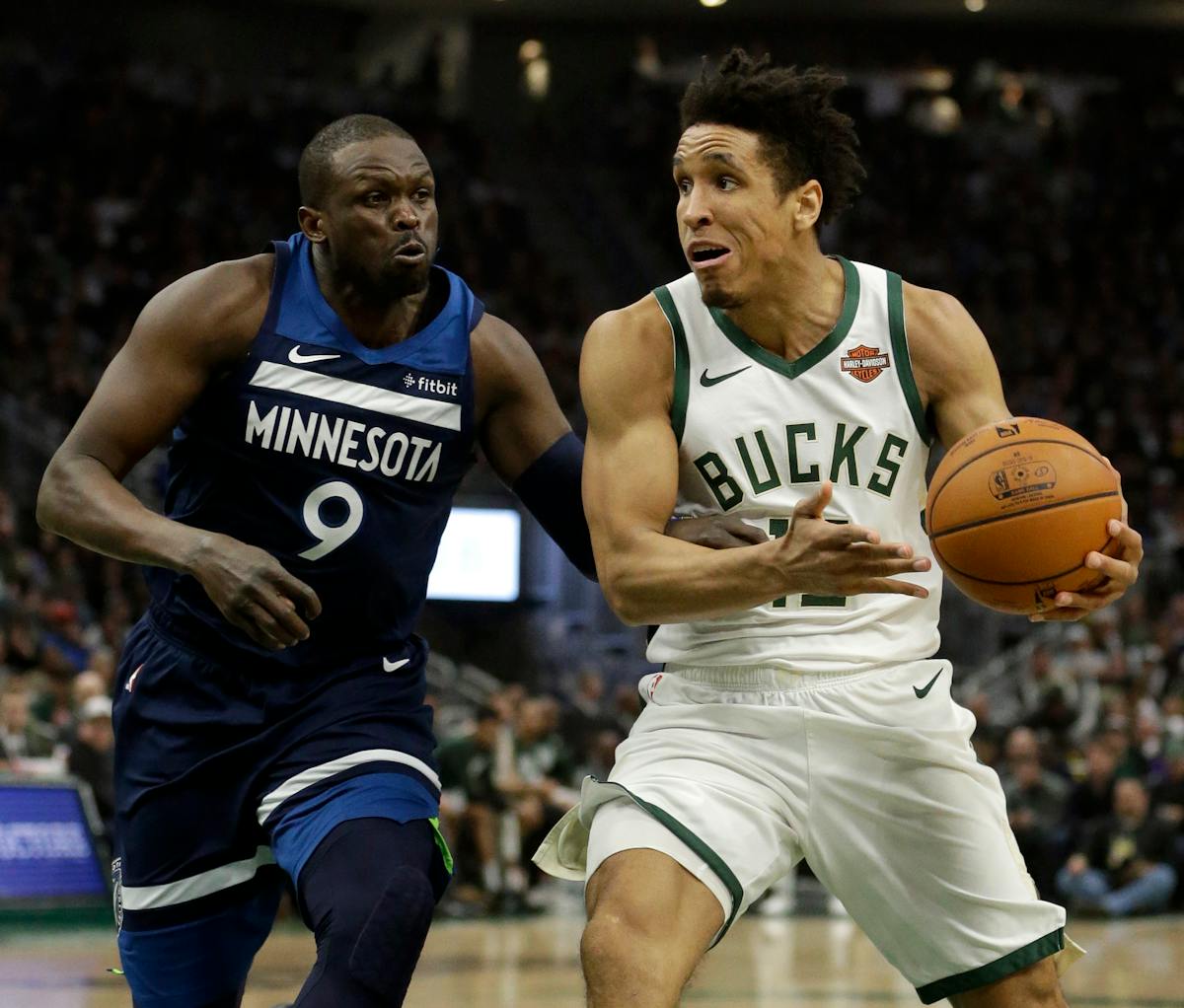 Milwaukee Bucks' Malcolm Brogdon, right, drives to the basket against Minnesota Timberwolves' Luol Deng (9) during the second half of an NBA basketbal