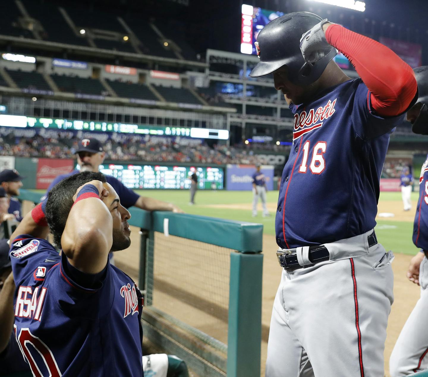 Minnesota Twins' Eddie Rosario, left, and Jonathan Schoop (16) celebrate a two-run home run by Schoop during the seventh inning of the team's baseball game against the Texas Rangers in Arlington, Texas, Friday, Aug. 16, 2019. (AP Photo/Tony Gutierrez)