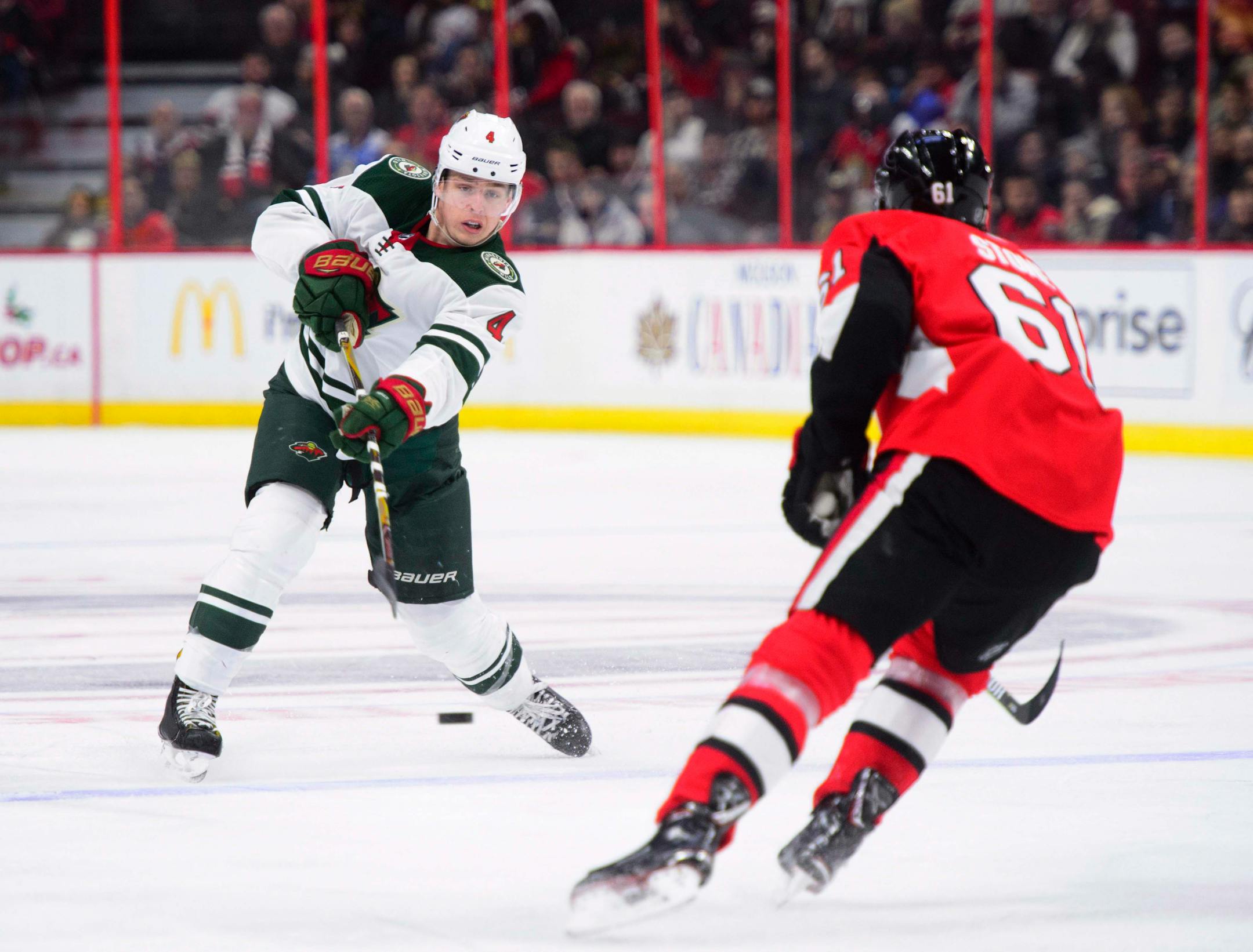 Minnesota Wild's Mike Reilly dumps the puck past Ottawa Senators' Mark Stone during third period NHL hockey action in Ottawa on Tuesday, Dec. 19, 2017. (Sean Kilpatrick/The Canadian Press via AP)
