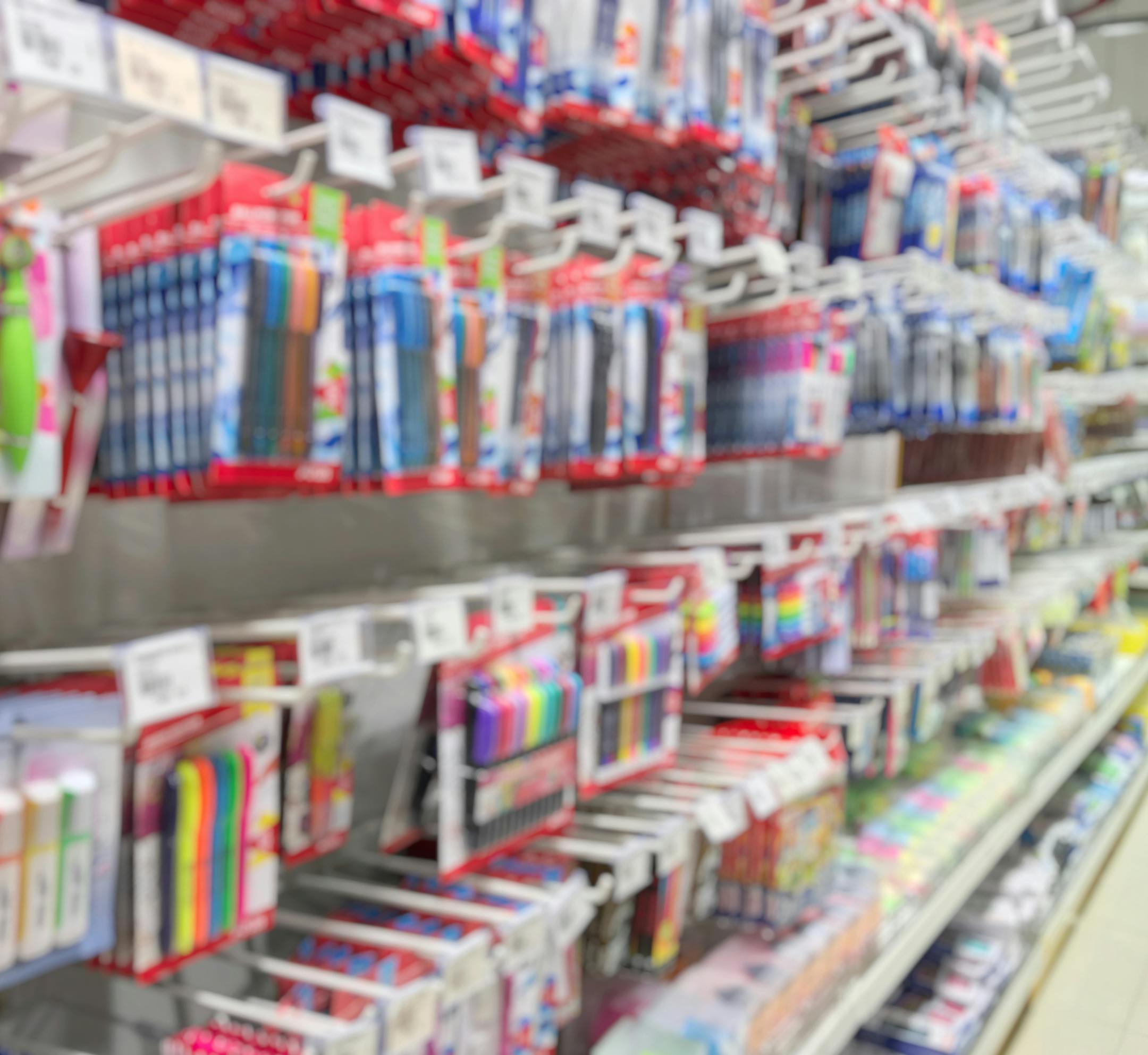 Blurred of stationery shop have many accessories such as pen, pencil, eraser, color, correction pen, post-it note, highlighting pen, ink and etc. Side view of School supplies on shelf for students.