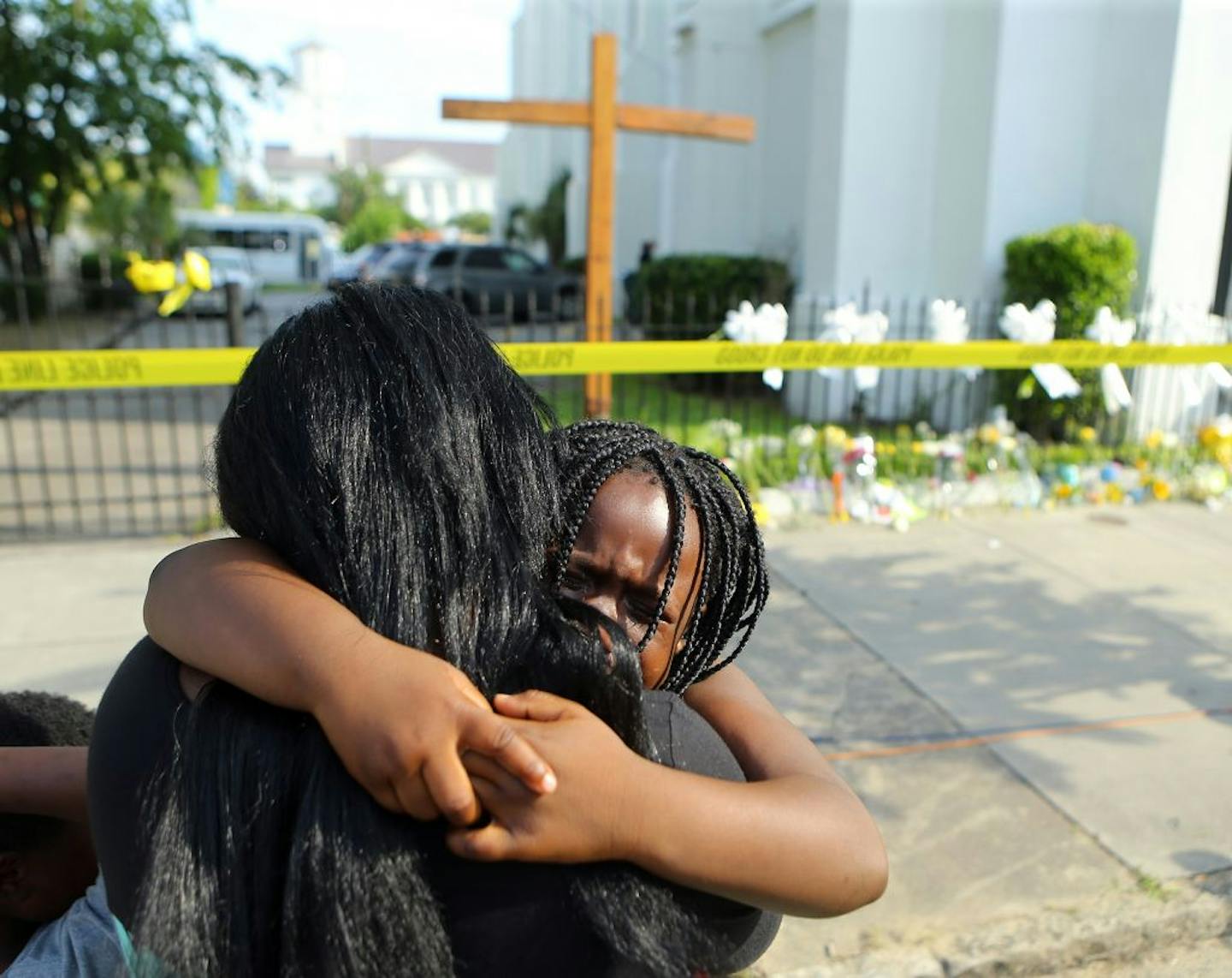 Kearston Farr hugs her 5-year-old daughter Taliyah visiting a memorial in front of the Emanuel AME Church on Friday, June 19, 2015 in Charleston, S.C. Dylann Storm Roof, 21, is accused of killing nine people during a Wednesday night Bible study at the church.