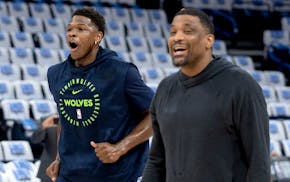 Timberwolves guard Anthony Edwards, left, reacts along with player development coach James White after making a half-court shot during warmups. The Wo
