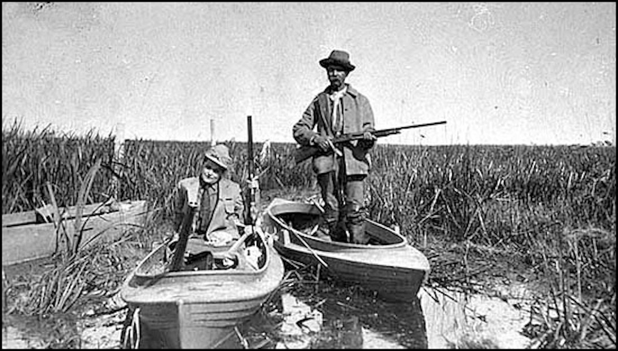 Charlie Hamilton, guide and market hunter in the Heron Lake area, in a duck boat, in about 1900.