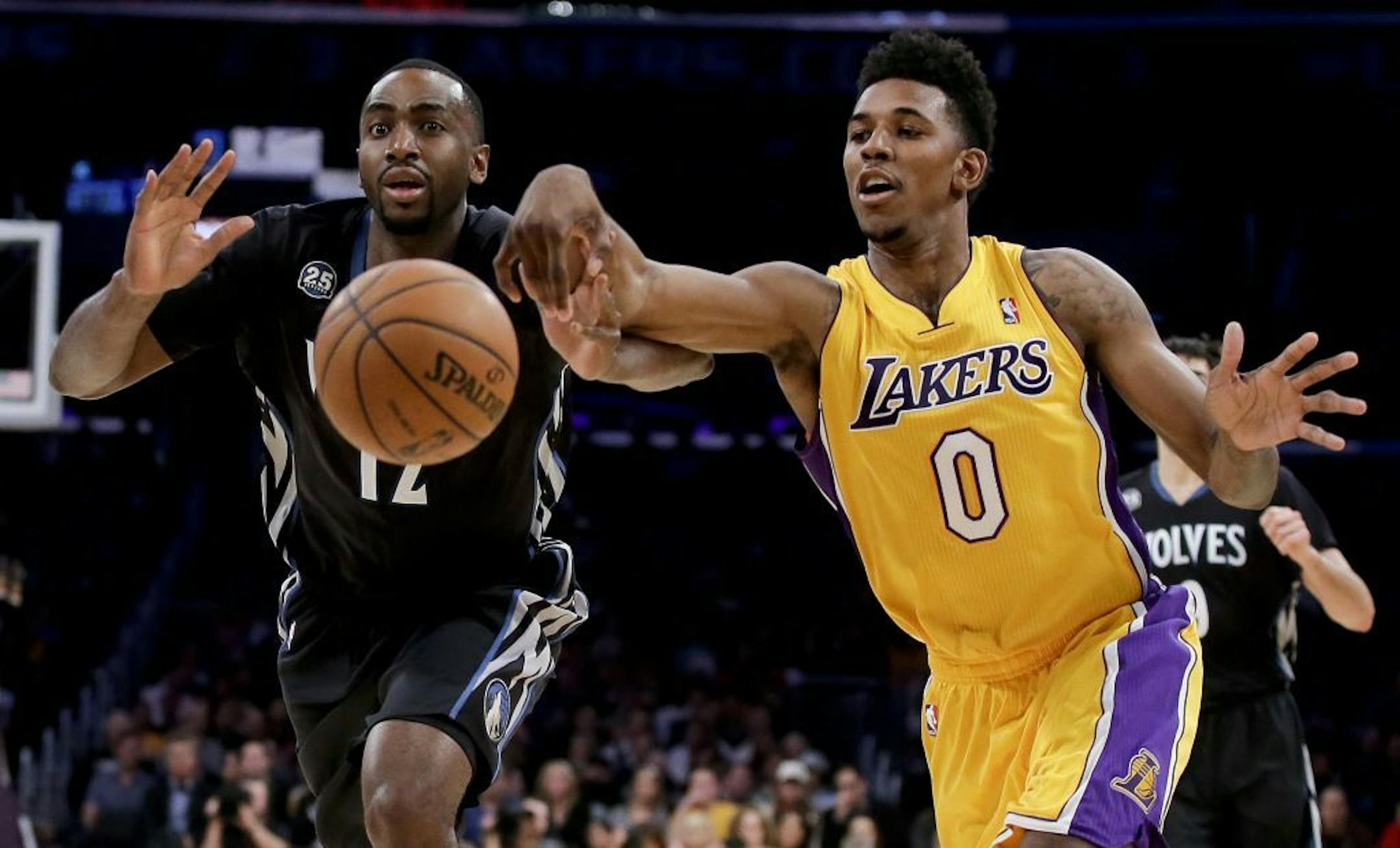 Minnesota Timberwolves forward Luc Richard Mbah a Moute, left, and Los Angeles Lakers forward Nick Young chase a loose ball during the first half of an NBA basketball game in Los Angeles, Friday, Dec. 20, 2013.