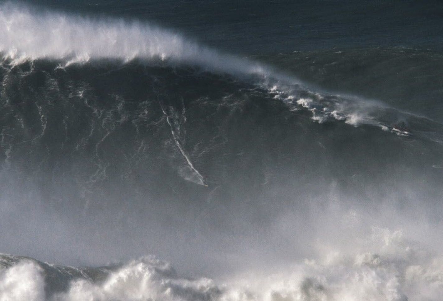 In this photo taken Nov. 8 2017, Brazilian surfer Rodrigo Koxa rides what has been judged the biggest wave ever surfed, at the Praia do Norte, or North beach, in Nazare, Portugal. On Saturday, April 28 2018, the World Surf League credited Koxa with a world record for riding the biggest wave ever surfed and said that its judging panel determined the wave was 80 feet (24.38 meters).