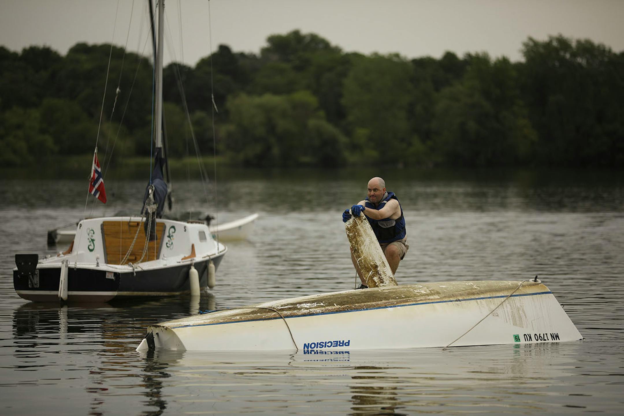 Martin Conroy waited for help from some others to right his overturned sailboat on Lake Nokomis Sunday afternoon. When he drove past the lake after the storm Sunday morning, "I saw that I was the only one flipped, so I went home and changed for my unplanned afternoon adventure."