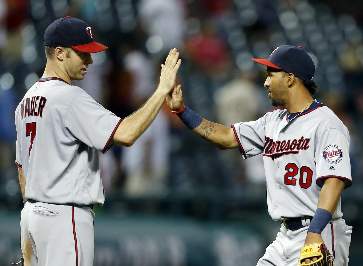 Minnesota Twins' Joe Mauer (7) and Eddie Rosario celebrate the team's 13-5 win against the Cleveland Indians in a baseball game Wednesday, Aug. 3, 2016, in Cleveland. (AP Photo/Ron Schwane)