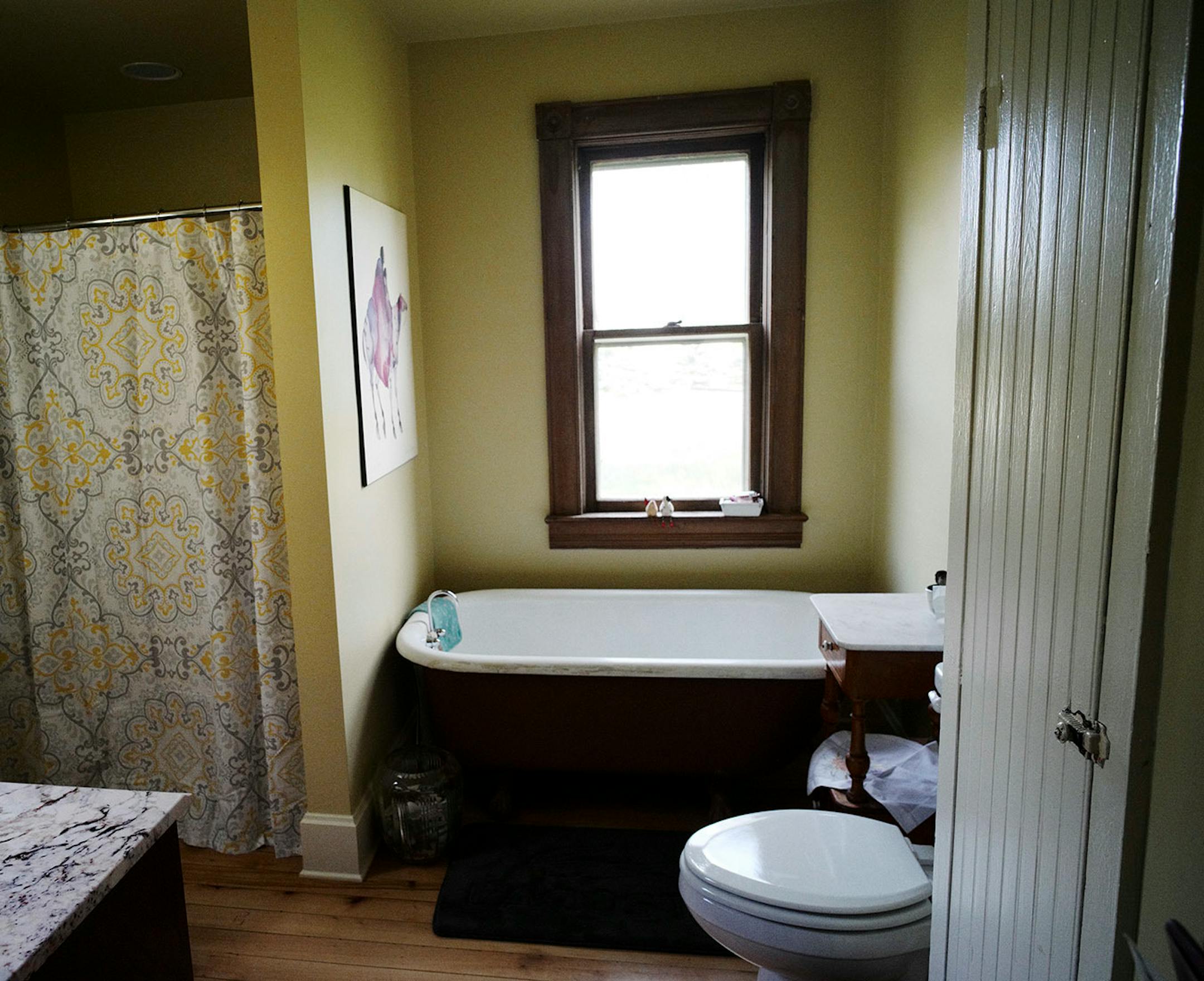 The remodeled bathroom features a reclaimed clawfoot tub from Bauer Brothers Salvage.