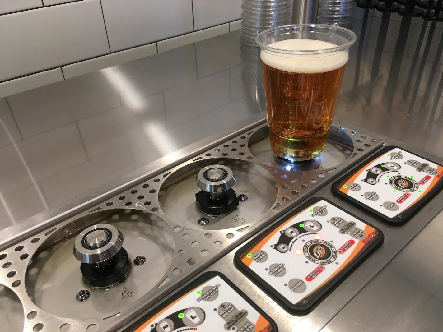 A magnetic device fills beers from below at Pizza Karma in Eden Prairie.