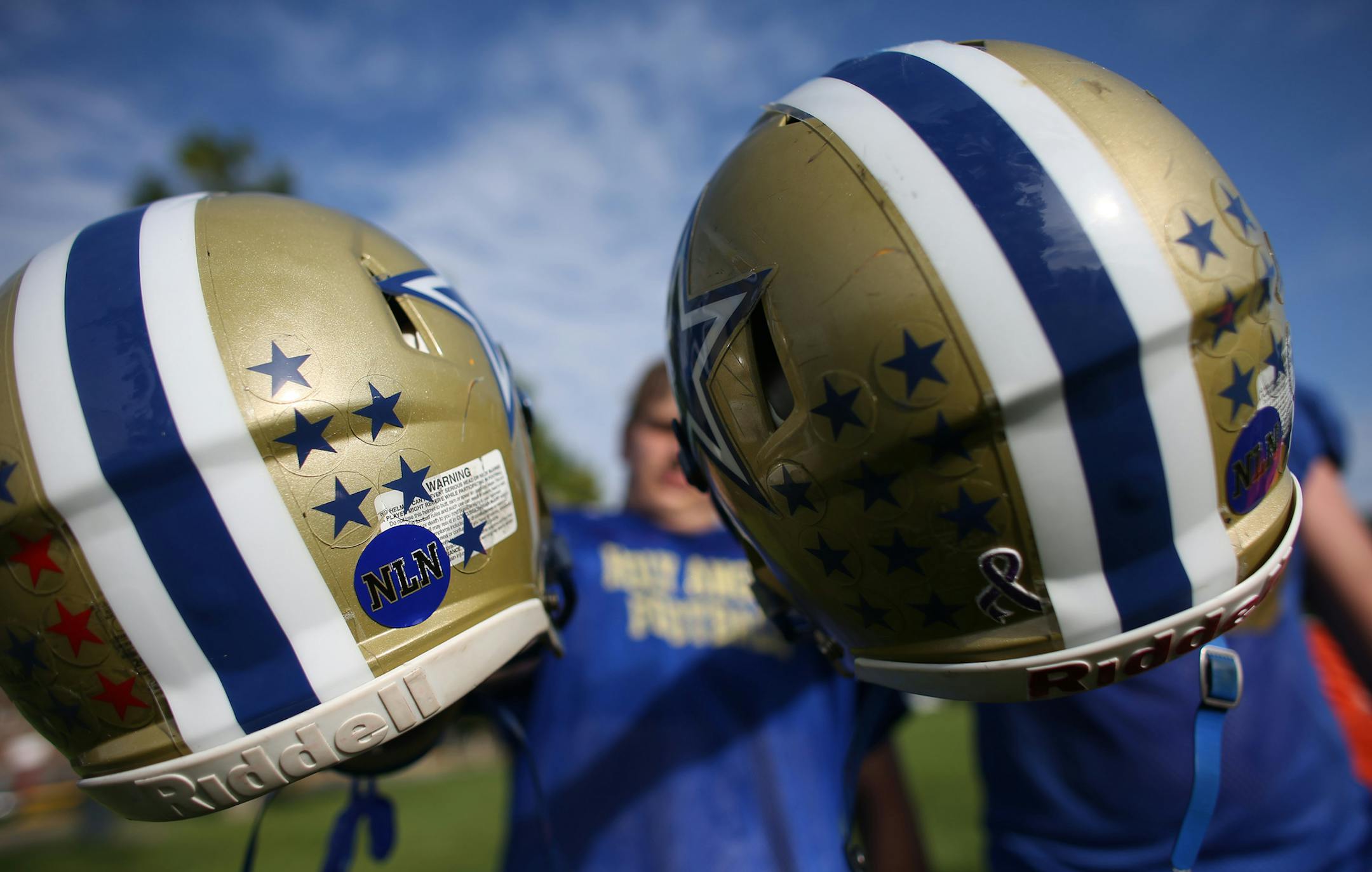 Eric Nygren and Jake Pierce held up their helmets that have NLN on them in honor of Nygren's father who passed away. ] (KYNDELL HARKNESS/STAR TRIBUNE) kyndell.harkness@startribune.com Holy Angeles practice in Richfield Min., Wednesday September 9, 2015. Captains, Eric Nygren and Jake Pierce, are playing despite having serious issues surrounding their fathers: Nygren's father died suddenly last summer and Pierce's father is in his second bout with cancer.