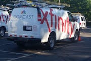 FILE - In this Sept. 17, 2015, file photo, Comcast trucks are parked in a lot in the company's Westford, Mass. operations center.