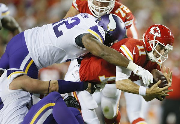 Kansas City Chiefs quarterback Alex Smith (11) was sacked by Minnesota Vikings defensive tackle Tom Johnson (92) in the second quarter during preseaso