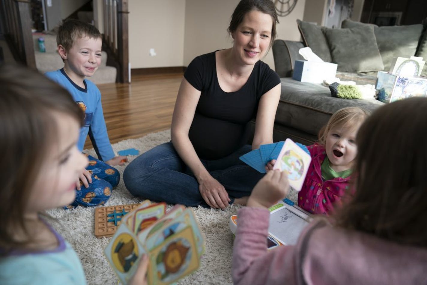 Jinger Birkholz, who is due with her sixth child in a week, played Old Maid with her children (from the left) Lily Birkholz, 5, Bobby Birkholz, Millie Birkholz, 2, and Evie Birkholz, 3, during a canceled school day due to cold weather in Elko, Minn., on Tuesday, January 29, 2019. Birkholz's school district gave her older children a "digital work day" where they spent 1-3 three hours at home reading and doing school work that morning. It was also declared a family "pajama day."