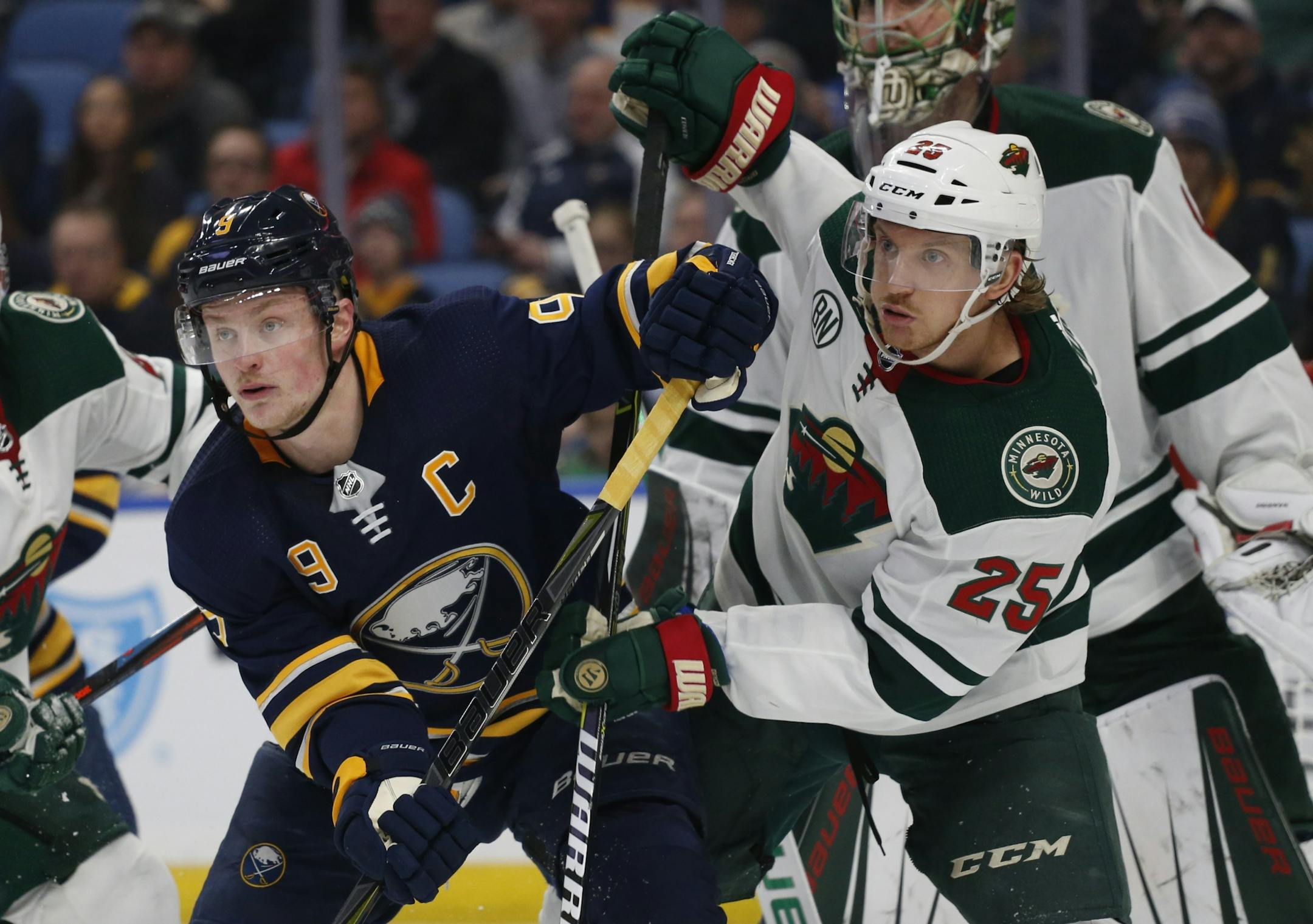 Buffalo Sabres forward Jack Eichel (9) and Minnesota Wild defenseman Joanas Brodin (25) battle for position during the third period of an NHL hockey game, Tuesday, Feb. 5, 2019, in Buffalo N.Y.