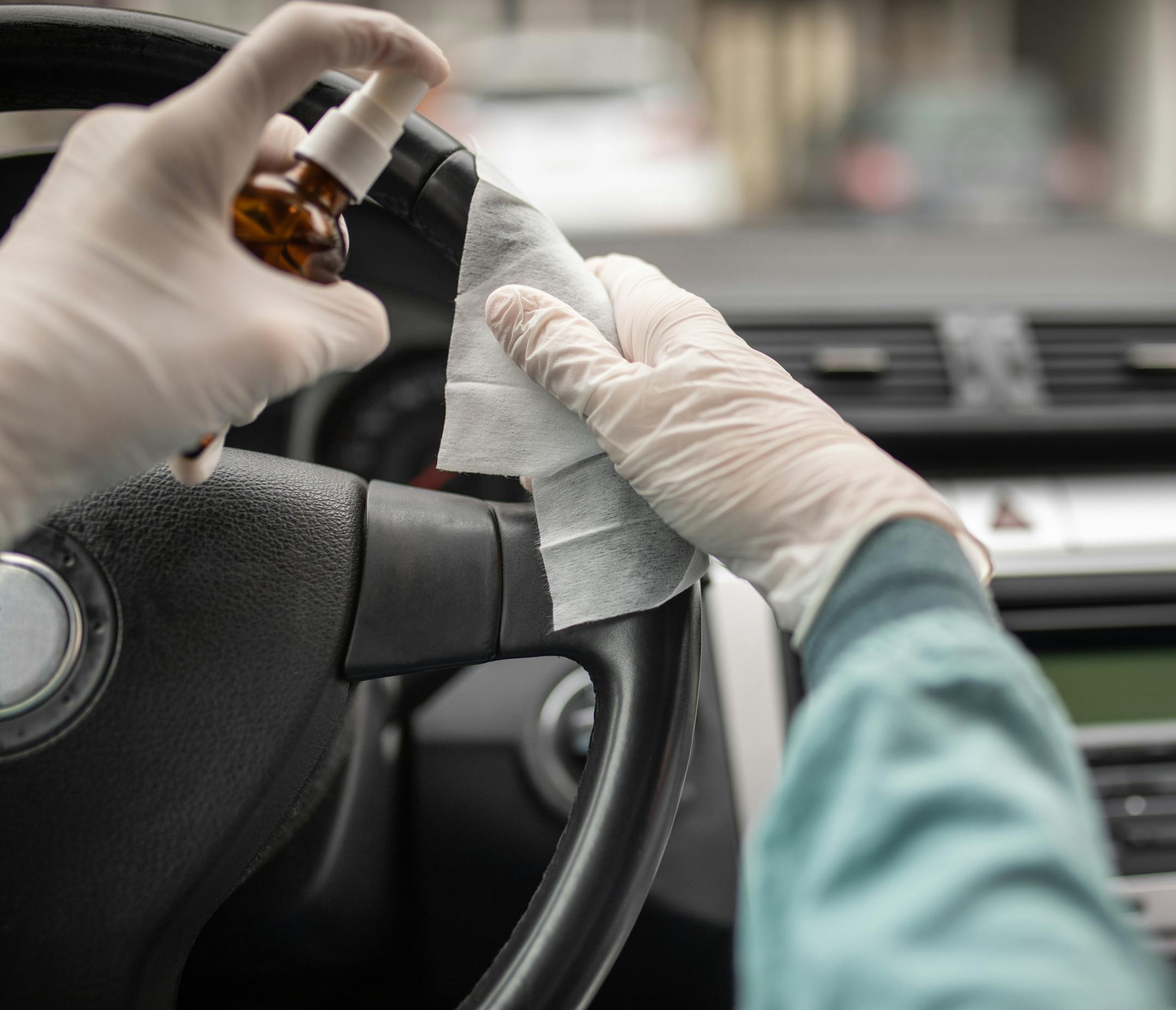 Person disinfecting and cleaning car interior with antiseptic liquid and wet disinfection wipes. Steering wheel is one of dirtiest parts in car and can contains viruses and bacteria. ORG XMIT: 775495007