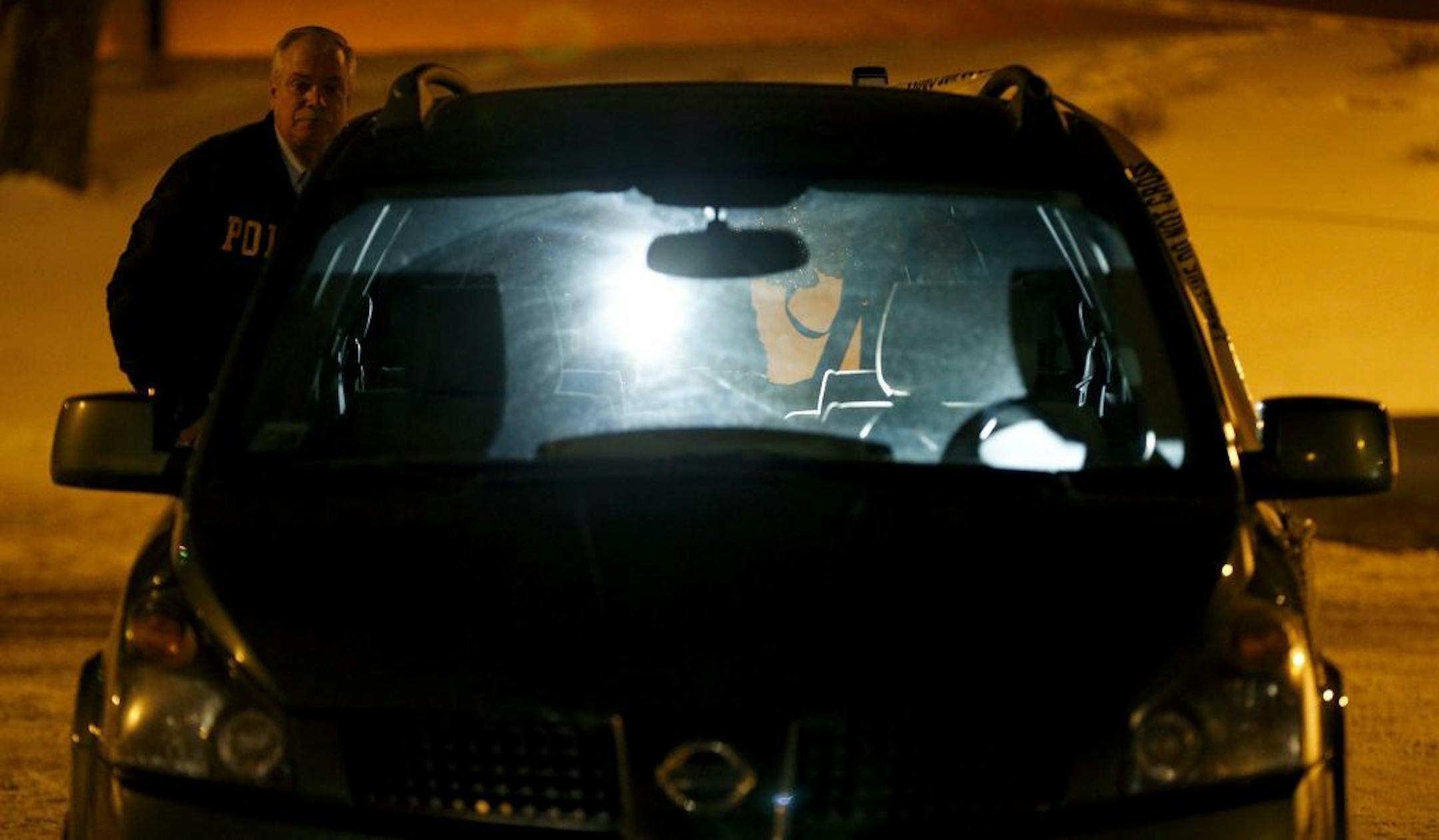 BCA Crime Scene Team investigators looked over a van in the Rainbow Foods parking lot in Oakdale, Minn. on Monday night.