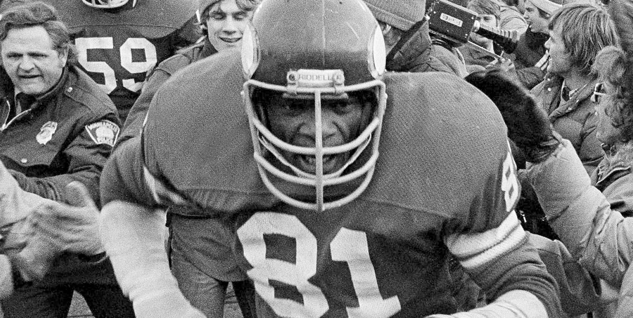 Defensive end Carl Eller led the victorious Vikings through a crowd of happy fans after they beat the Rams for the NFC championship in 1976.