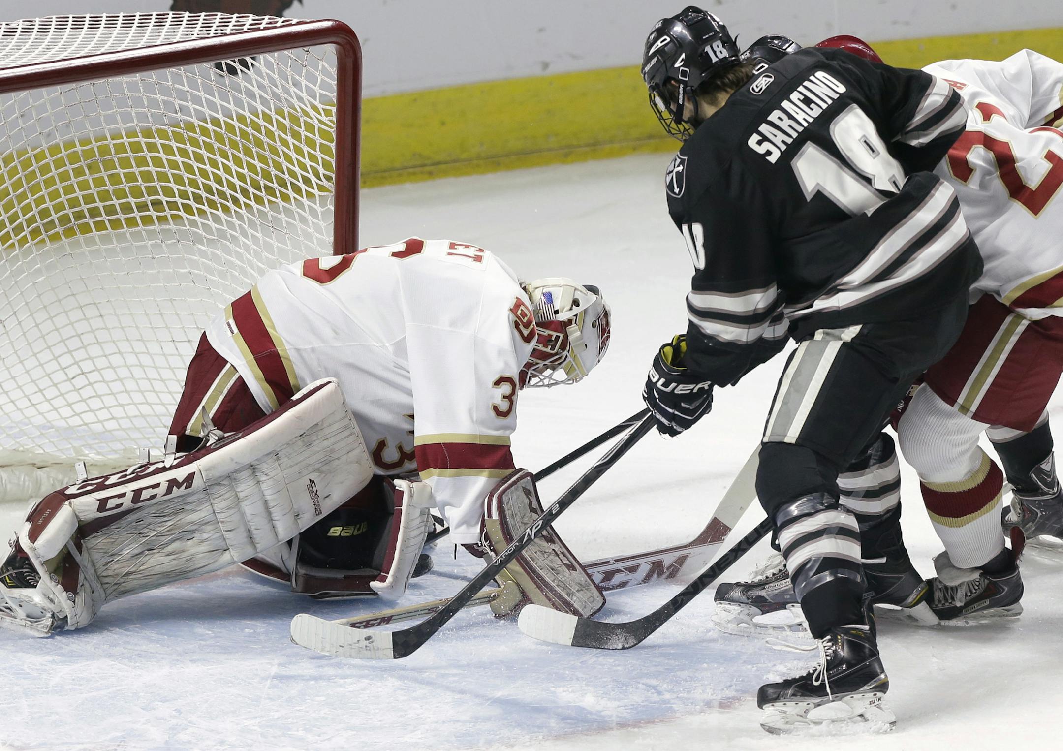 Denver's Tanner Jaillet, left, turns away a shot as Providence's Nick Saracino, center, and Denver's Joey Laleggia, right, look for a rebound during the first period of an NCAA East Regional hockey tournament game, Sunday, March 29, 2015, in Providence, R.I. (AP Photo/Steven Senne)