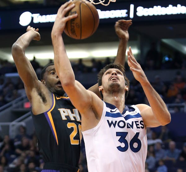 Timberwolves forward Dario Saric drives to the basket as the Suns' Josh Jackson defends during the first half