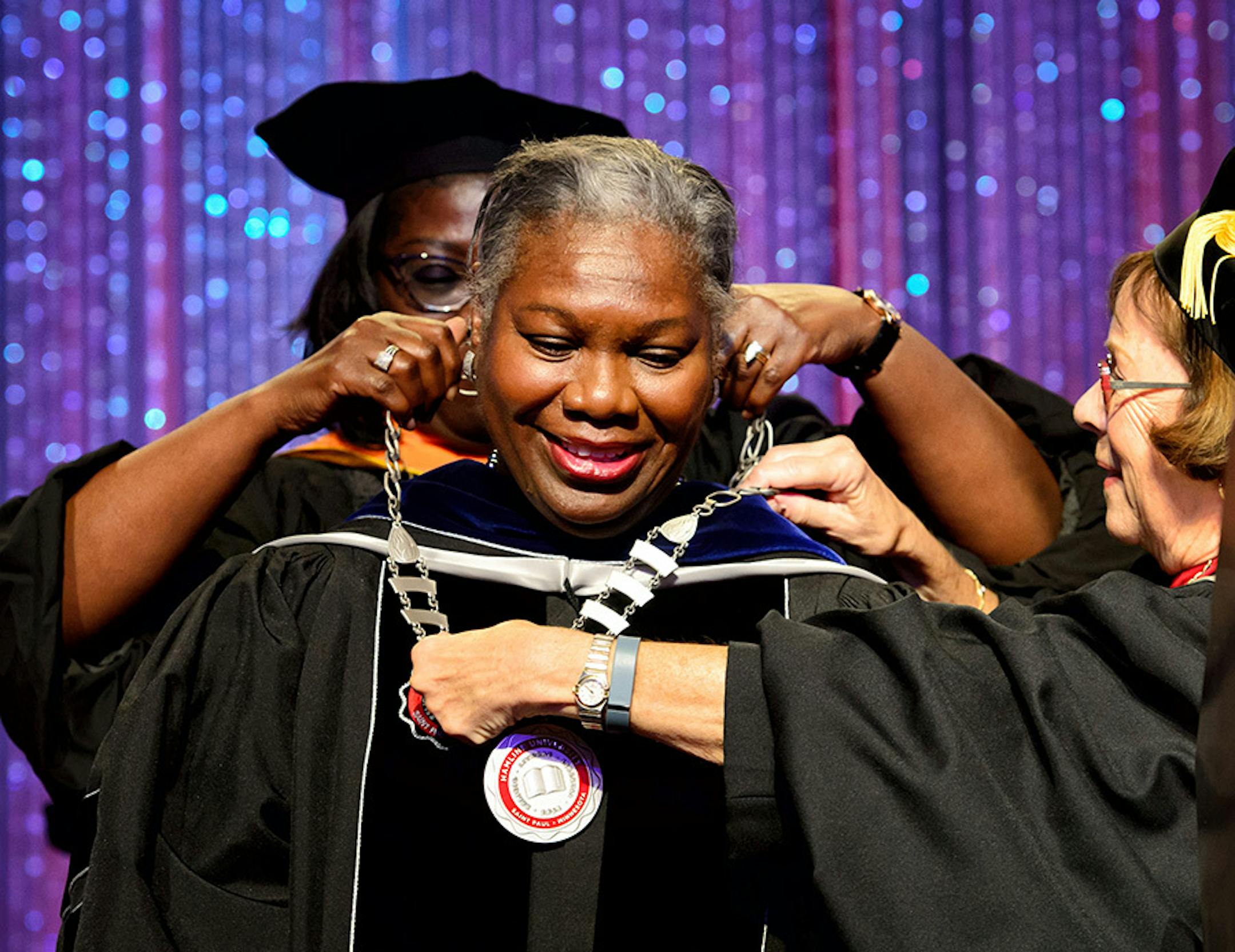 Dr. Fayneese Miller received the Hamline University Seal. She happily kicked off her shoes so the presenters could reach over her head.