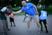 Ryan Sayre of the St. Cloud Police Department plays basketball with kids from the south-side neighborhood at the Community OutPost in June 2018. The c