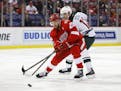 Detroit Red Wings defenseman Mike Green (25) takes the puck from Minnesota Wild center Eric Staal (12) in the first period of an NHL hockey game Sunda