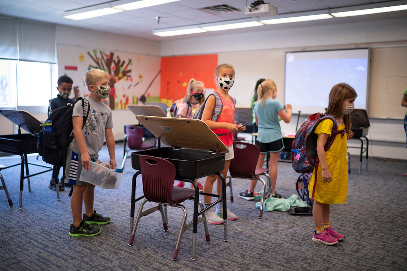 Second-grade kids stood with their belongings before joining other in-school day-care kids for supervision by YMCA staffers at Rosemount Elementary School in September.