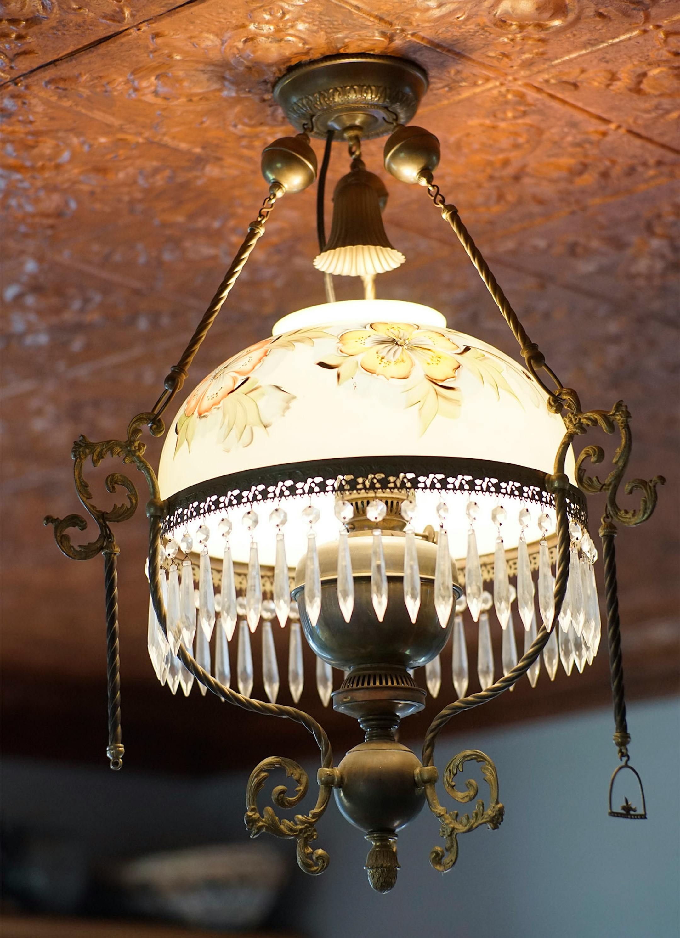 A Victorian art glass light fixture from a California hotel illuminates the restored tin ceiling.