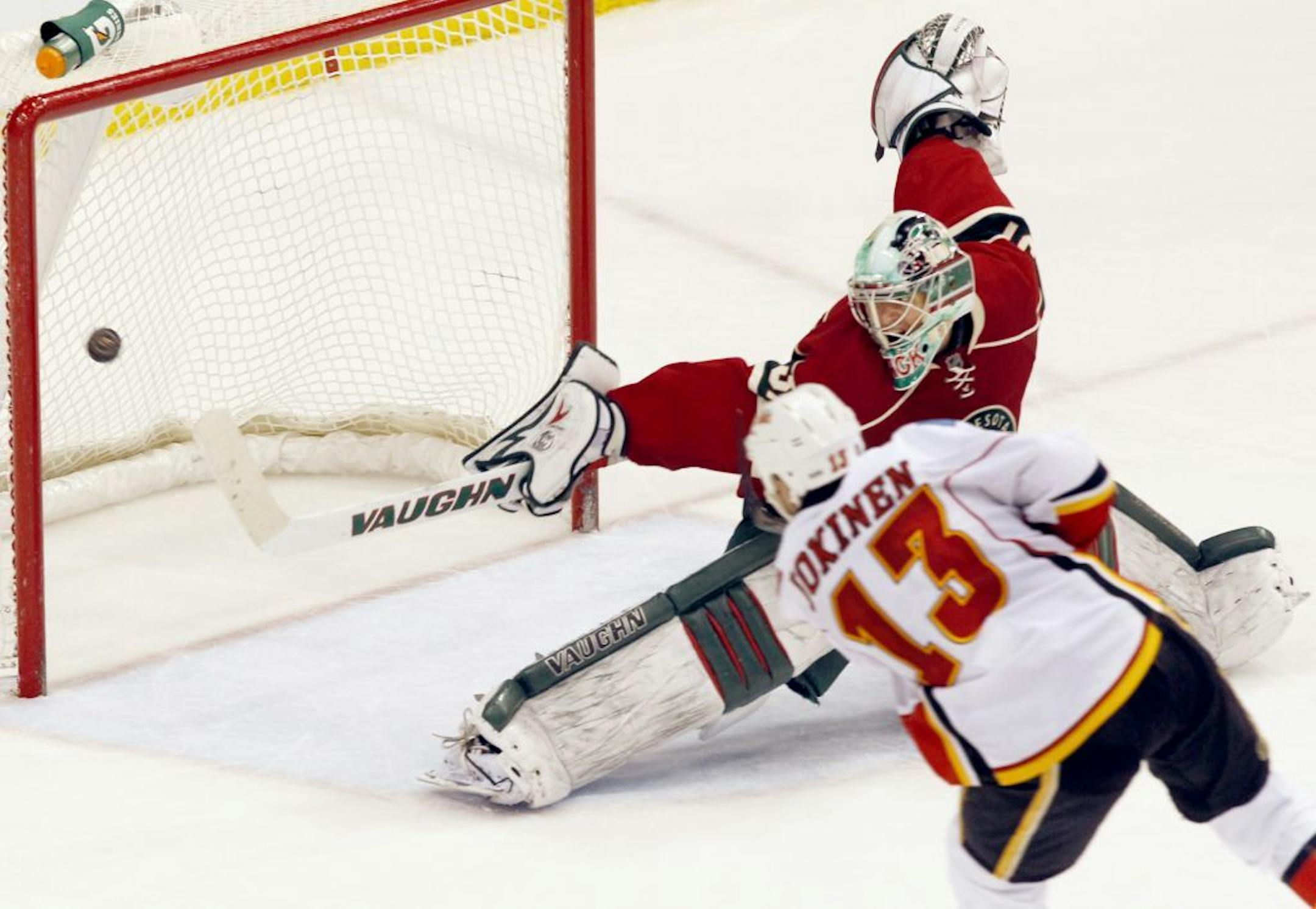 Calgary Flames center Olli Jokinen (13), of Finland, scores on Minnesota Wild goalie Matt Hackett (31) during the third period of an NHL hockey game, Sunday, March 11, 2012, in St. Paul, Minn. The Flames won 4-3.