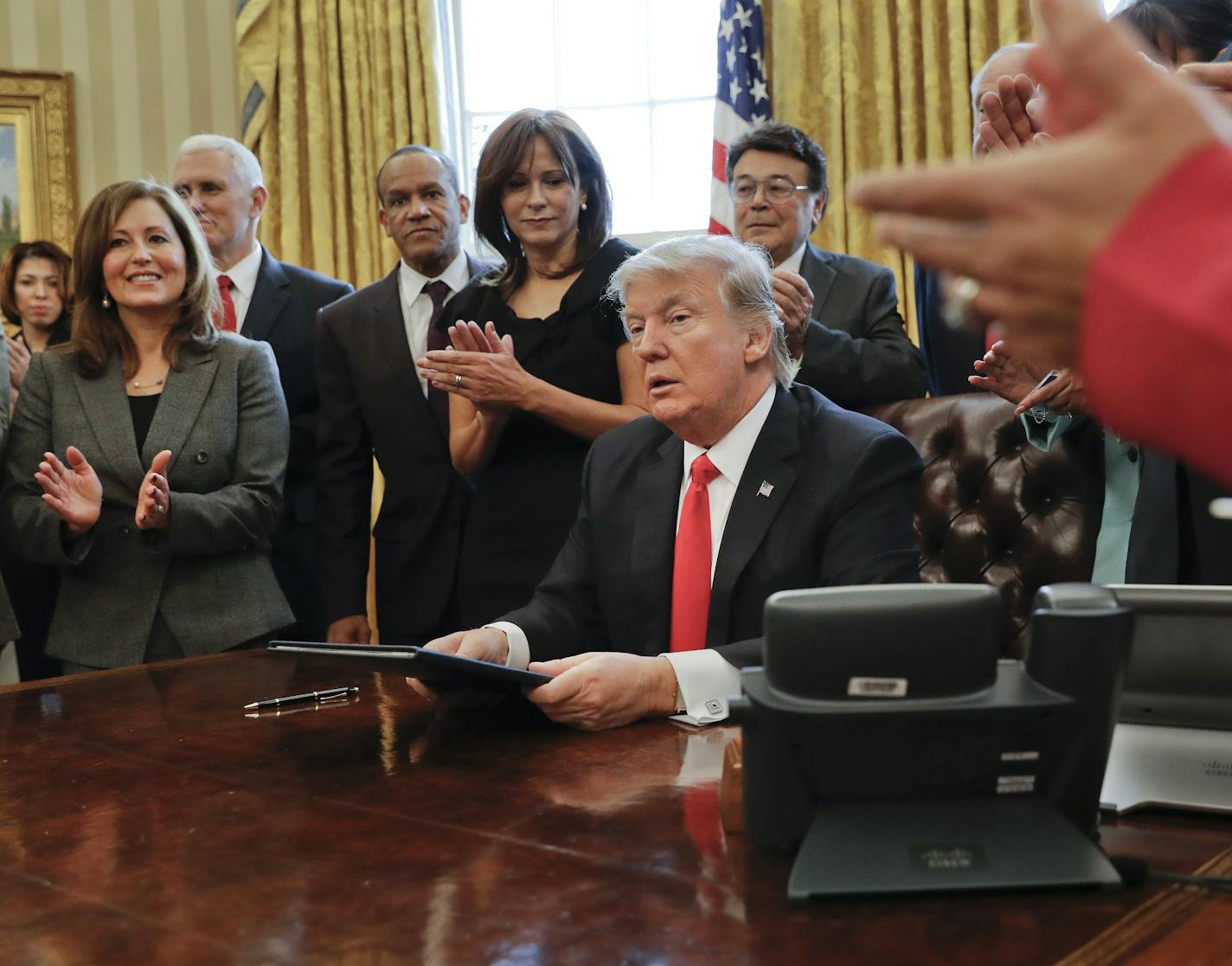 Small business leaders applaud President Donald Trump after he signed an executive order in the Oval Office of the White House in Washington, Monday, Jan. 30, 2017. Trump order is aimed at significantly cutting regulations. White House officials are calling the directive a "one in, two out" plan. It requires government agencies requesting a new regulations to identify two regulations they will cut from their own departments. (AP Photo/Pablo Martinez Monsivais)